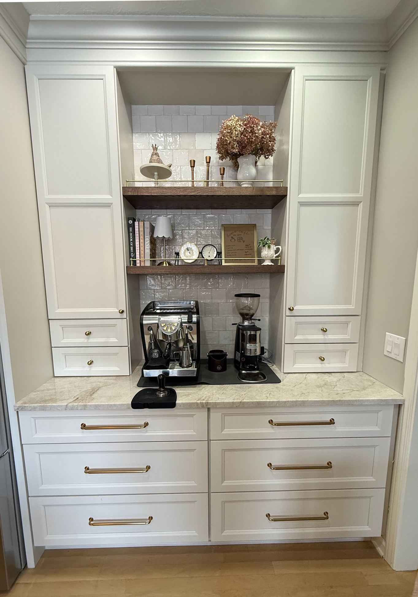 Built-in coffee bar with floating white-oak shelves, glazed tile backsplash, and brass hardware