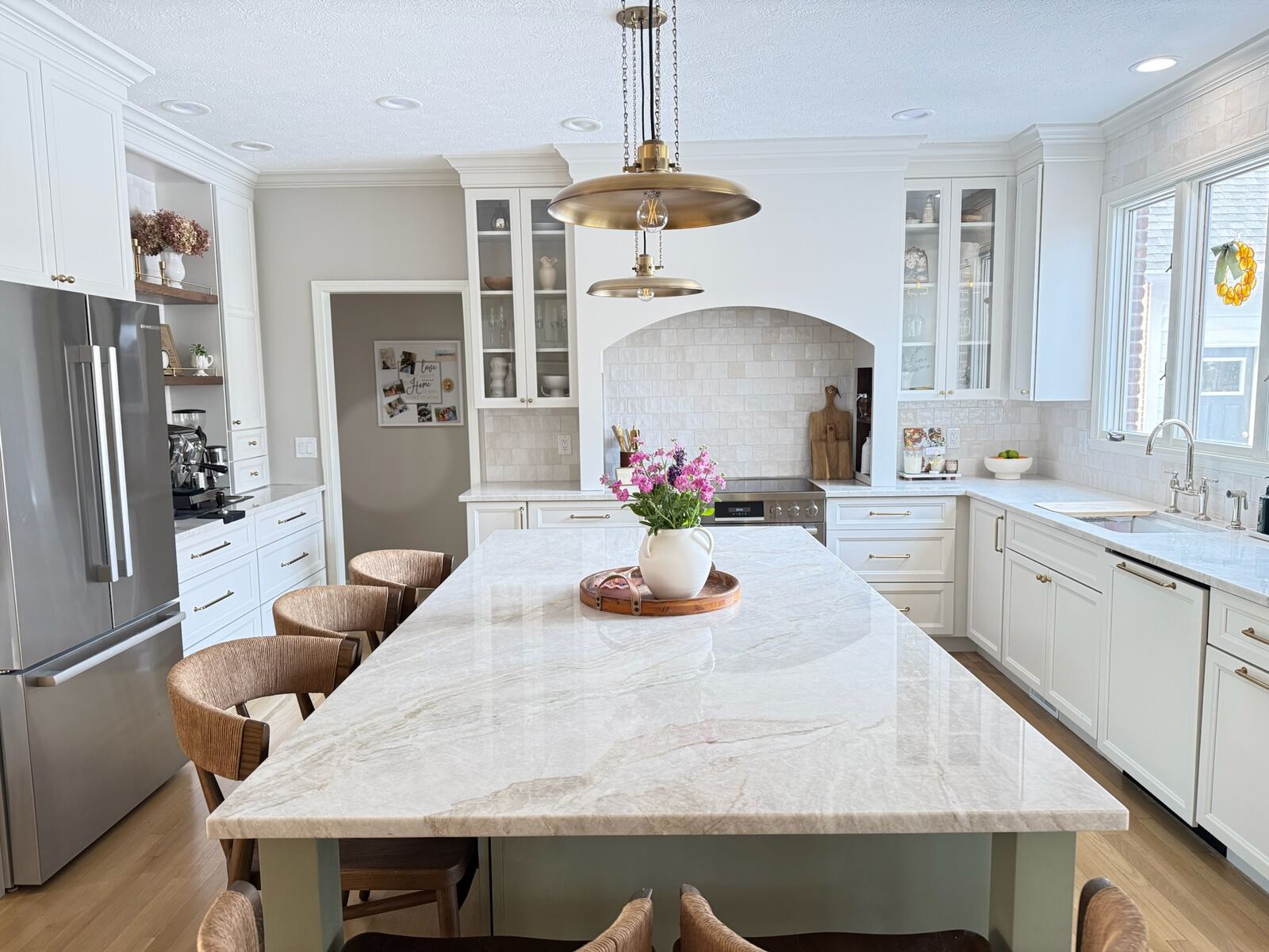 Completed kitchen remodel by Ried Build — white cabinetry, marble island, and brass pendant lighting